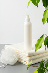 White cosmetics container mockup with towels on gray background