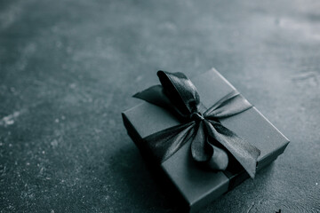 Black Friday sale concept. Gift box with black ribbon isolated against black background, top view
