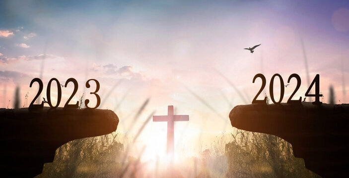 New Year 2024 and 2023 on on the mountain at sunset with  white cross background