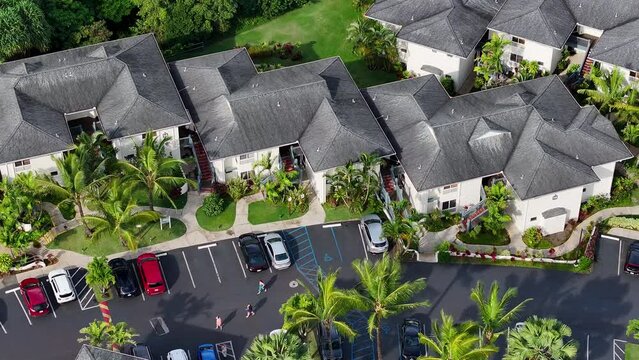 Aerial Princeville luxury resort parking roofs Kauai Hawaii. Expensive luxury homes, resort, condominium and golf club near coast. Green landscape. Hawaiian Island. Garden Isle. Economy tourism based.