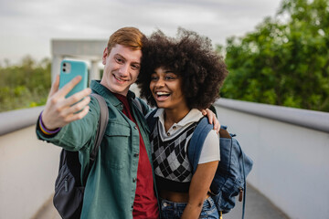 Selfie of multiracial student couple smiling at camera
