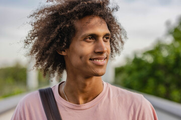 portrait of hispanic man with curly hair outdoors