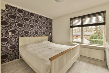 a bedroom with purple and white wallpaper on the walls, along with a bed in front of a window