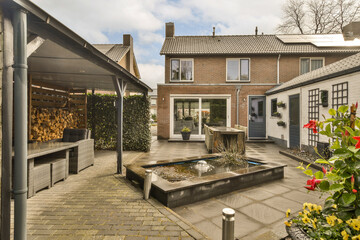a backyard area with a fountain and fire pit in the middle, surrounded by brick paversed buildings...