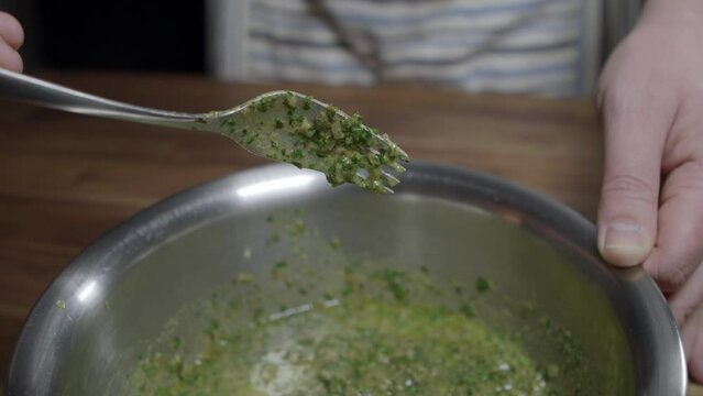 Delicious caf&eacute; de paris sauce is prepared by a chef. Mixing all ingredients in a metal bowl. No face, close-up.