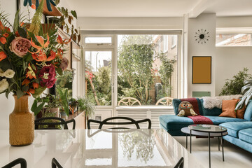 a living room with blue couches and colorful flowers in vases on the coffee table next to the sofa