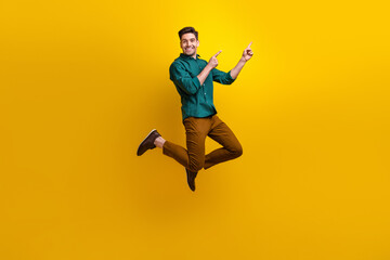 Obraz premium Photo of satisfied nice man dressed stylish clothes presenting empty space benefit news poster isolated on yellow color background