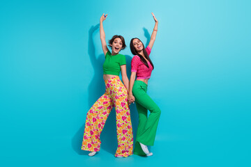 Full body photo of two careless positive women rejoice arms together lesbians optimistic vibes good...