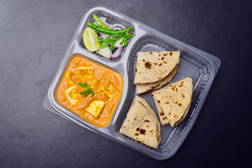 Shahi paneer and tawa roti served with onion chilli in disposable plate