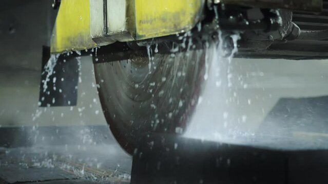 Cutting porcelain stoneware material on a special modern machine with water cooling. Manufacture for the production of slabs of granite and porcelain stoneware, industry. Slow motion