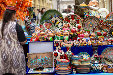 Ornate colorful oriental tableware and ceramics in market window. Seller and buyer. Silk Road. - obrazy, fototapety, plakaty