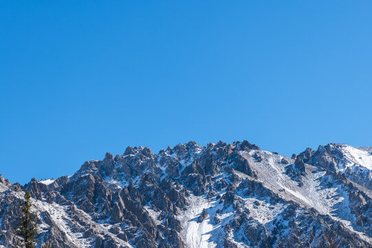 Snow on rocky peaks and blue sky. Ala-Archa Natural Park in Kyrgyzstan.