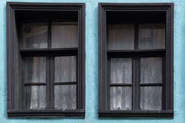 Fototapeta na wymiar Two windows on the blue facade of the house.