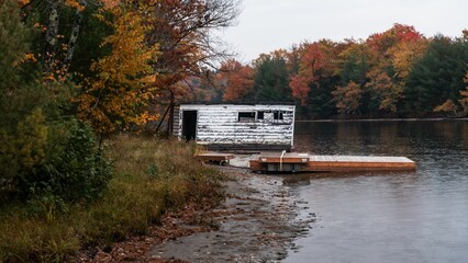 Boathouse beyond repair in autumn colors in the Muskoka River, Bracebridge, Ontario, Canada.