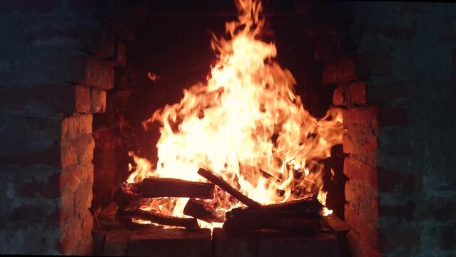 Open fire with tall flames inside outdoor rustic grill oven and grid. Firewood burning hot, real time, no people