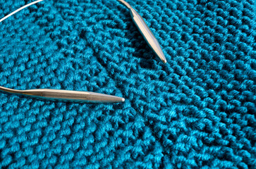 Garter stitch. The pattern is knitted with large knitting needles from wool blend yarn.