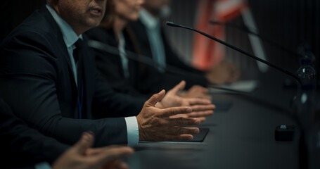 Close Up On Hands of Caucasian Male Organization Representative Speaking at Economic Conference. Head Of USA Delegation Delivering Speech at International Political Summit. Diverse Delegates Listening - obrazy, fototapety, plakaty