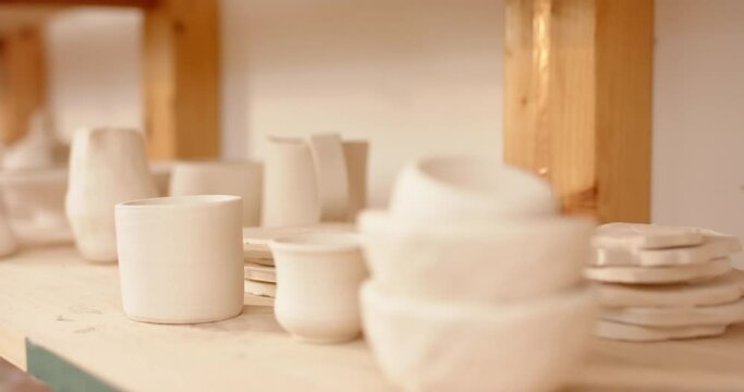 Ceramic products lying on shelf in pottery studio