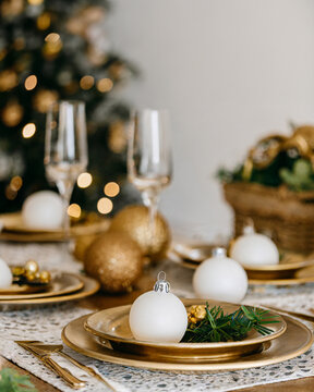 Festive holiday decor on indoor table: Christmas celebration with beautiful decoration, tree, and plates. With copy space