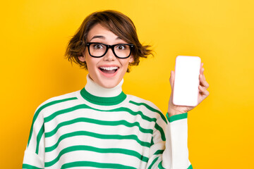 Photo of funky sweet girl dressed striped sweater eyewear rising apple samsung iphone device empty space isolated yellow color background