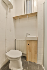 a bathroom with a sink and toilet paper dispensed on the wall next to it is a wooden cabinet
