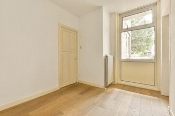 an empty room with wood floors and white walls, there is a door leading to the left side of the room