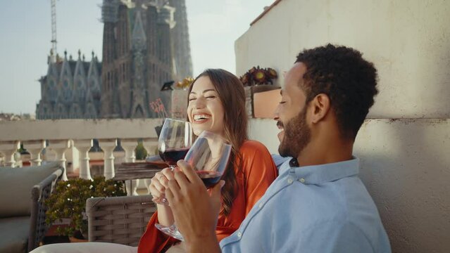 Young multiethnic couple dating for a romantic dinner on a beautiful terrace penthouse in Barcelona