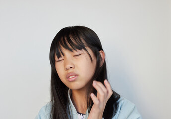 嫌な顔で悩んでいる小学生の女の子の様子