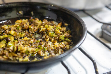 cooking chopped zucchini with an old frying pan