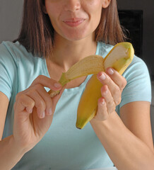 Young woman peeling banana in the kitchen. - 668078838