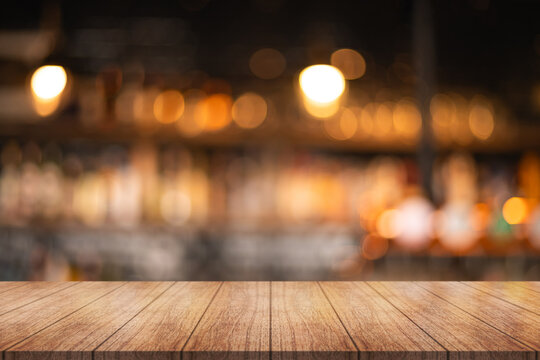 Empty wooden table top with lights bokeh on blur restaurant background.	
