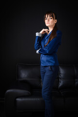 Confident Businesswoman Standing in Front of Leather Couch