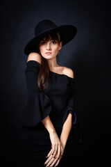 Elegant Woman in Black Hat and Off-Shoulder Dress