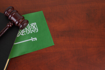 Saudi Arabia legal and law concept, judge gavel with book on table and Saudi Arabia flag.  The...
