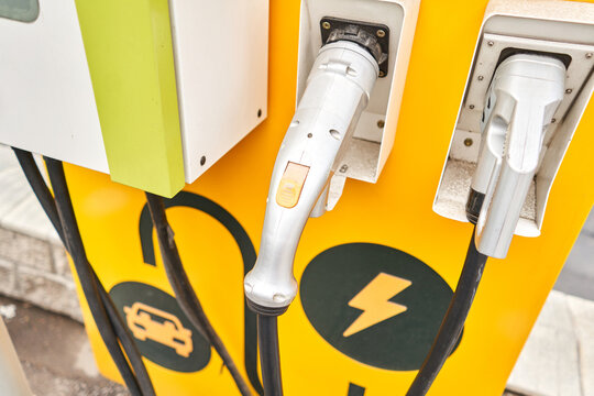 Power supply for electric car charging. Electric car charging station. Close up of the power supply plugged into an electric car being charged. High quality photo