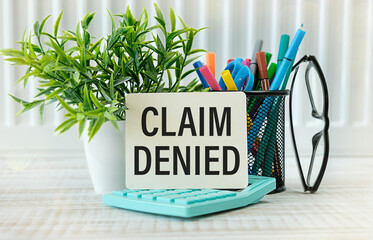 Claim denied. text on paper on a notepad on the table