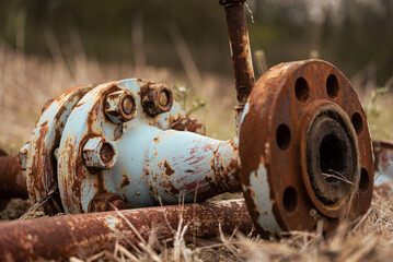 Old rusty metal gas pipe, left on a field, abandoned pipeline. 
