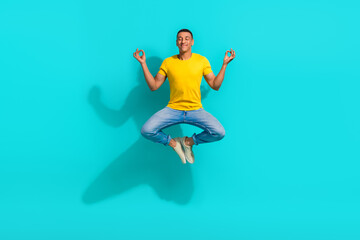 Obraz premium Full length portrait of calm energetic person jump flying meditate isolated on vibrant turquoise color background