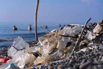 Close-up of a bunch of collected cellophane bags, plastic on the seashore on a pebble beach in the...