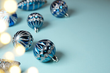 Christmas Festive Banner, Background. Monochrome side view with various silver blue Christmas Decoration Balls over light blue background. Bokeh effect. Space for text.
