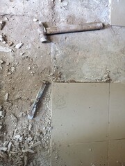 Old tools on floor. Dismantling old floor tiles. Renovations.Chisel and hammer on concrete slab....