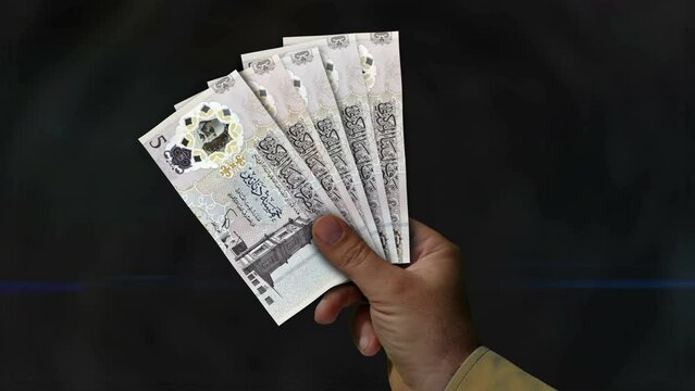 Libya Dinar money holding. Fan of banknotes in hand. LYD paper cash. Concept of income, success, business, tax, economy and finance.