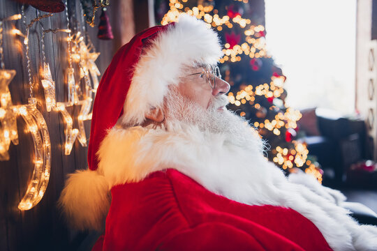 Photo of dreamy positive santa claus dressed red eyewear enjoying christmas time indoors north pole home