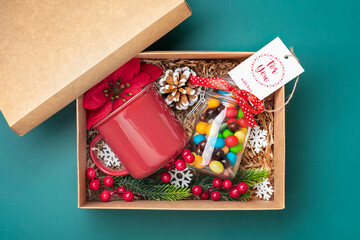 Handmade care package, seasonal gift box with candies, gingerbread, xmas decor on green table...