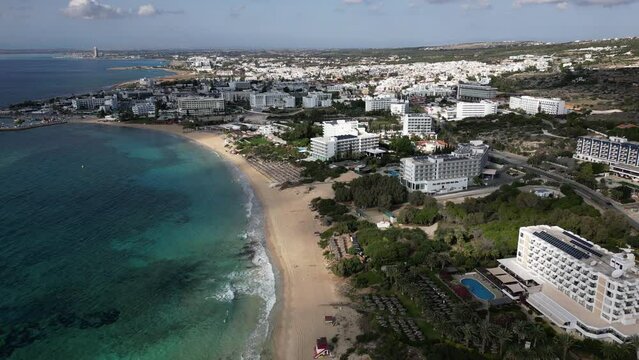 Retreating aerial view of beaches and resort hotels of Agia Napa city, a popular vacation destination in Cyprus, tourism in Europe
