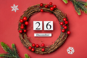 Christmas wreath and wooden calendar with date December 26 on red background Boxing Day occurs annually on December 26 (day after Christmas). In 2023, Boxing Day falls on Tuesday, December 26 Xmas day - 668115413
