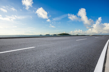 Asphalt highway road and coastline landscape under blue sky