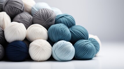 Fototapeta premium Blue, white and greya Balls of wool yarn lie on a whute background, hobby knitting