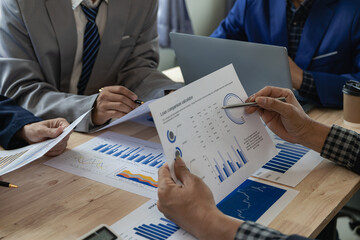 Businessman or accounting team analyzing graph data chart and laptop dashboard to prepare statistical reports and discuss financial data to analyze market data. Close-up image