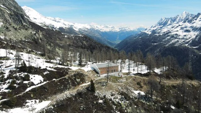 spectacular aerial view of the secluded Swiss mountain huts of Capanna Piansecco above the valley of Bedretto below the iconic Nufenen Pass showing the mountain of Poncione di Vespero in Switzerland 